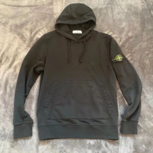 Stone island hoodie - Hej! Säljer en stone island hoodie i färgen svart Skick 9,5/10 nästan intill nyskick!!! Storlek medium fint med en lätt batch på sidan tveka inte för att höra av er ///