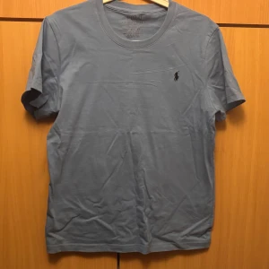 Blå t-shirt  - Ljusblå tröja som inte används längre. Modellen är slim fit och tillverkad i mjuk 100% bomull.