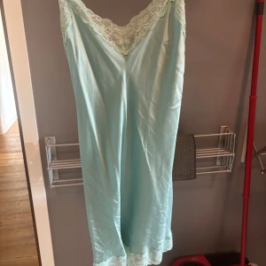 Mintgrön/turqoise spetsklänning från Intimissimi - Supersöt långklänning i mintgrönt/turqoise från Intimissimi. Klänningen har tunna axelband, v-ringning med spetsdetaljer och är 100% silke. Sista bilden är bara ifrån zalando. Linnet finns ej längre att köpa i denna färg från vad jag har sett.