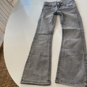 Grå bootcut jeans från Gina Tricot - Snygga grå jeans från Gina Tricot i storlek 140. Modellen har klassisk femficksdesign, knapp och dragkedja fram samt bootcut-ben som ger en cool siluett. Jeansen är tillverkade i mjukt denimtyg och passar perfekt till sneakers eller boots. Inga defekter men är använda.