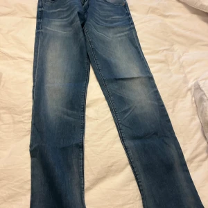 Blå slim jeans från Replay - Snygga blå jeans från Replay i slim fit-modell. Jeansen har klassisk femficksdesign, dragkedja och knapp framtill samt Replay-logga vid fickan. Materialet är mjukt jeans-tyg med lätt tvättad look och snygga detaljer.