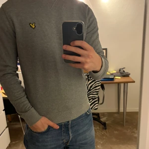 Grå Lyle & Scott tröja - En väldigt simpel men snygg grå Lyle & Scott tröja. Tröjan är i mycket bra skick syns knappt att jag använt den! Lite liten på mig (186cm) Mått finns på bilderna. Vid fler funderingar hör av er!