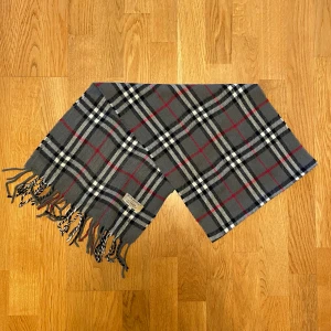 Grå Burberry halsduk i kashmir - Säljer en grå halsduk från Burberry. Halsduken är i 100% kashmir och den är i gott skick. Var inte rädd för frågor.