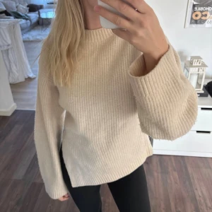 Beige stickad tröja &Other Stories - Supermysig beige stickad tröja från &Other Stories med ribbad struktur. Tröjan har rund halsringning, långa ärmar och en relaxed passform. Perfekt att slänga på sig när det är kyligt ute. Tröjan är i äkta Ull därav har den blivit nopprig väldigt lätt.