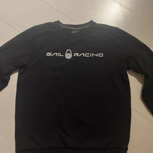 Svart Sail Racing sweatshirt 170 - Svart sail racing sweatshirt med fina detaljer i storlek 170