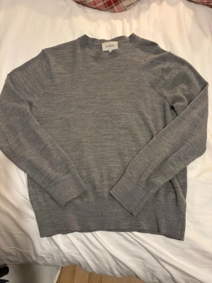 Grå stickad tröja från Sandö - Grå merinoullströja från Sandö i fint skick med mjuk premiumkvalitet och snygg passform. Lättmatchad och väldigt efterfrågad. Säljs snabbt – köp innan någon annan hinner ta den. ✅Beställ nu = Kommer innan Jul ✅Ställ frågor = Snabbt svar 