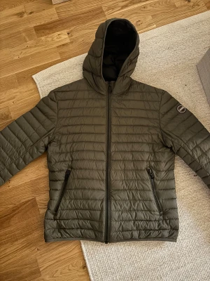 Olivgrön pufferjacka från Colmar - Säljer en olivgrön pufferjacka från Colmar den är i storlek 50 vilket motsvarar medium sitter bra på mig så är 180 lång. Den är varsamt använd och köpt för vintern. Inga skador på jackan 