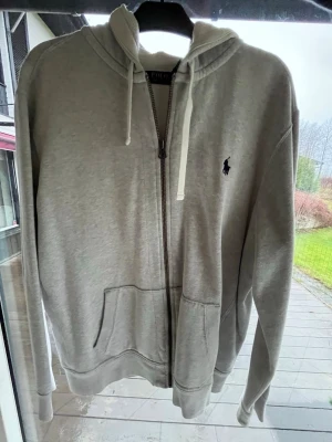 Ralph Lauren Zip Hoodie - Skön Zip hoodie från Ralph Lauren, tröjan är i ett mycket bra skick och endast använd fåtal gånger. Stilren och matchar allt. Hör av dig vid funderingar.