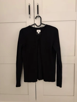 Svart kofta i bomull - En klassisk svart kofta från Saint tropez i mjuk bomull. Koftan har rund halsringning, långa ärmar och knäppning framtill. 