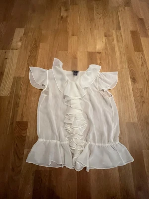 Tunn blus Ralph Lauren - Aldrig använd säljer då jag inte gillar så tunna blusar,Toppen har fina volanger och knappar som man själv kan välja hur många som ska vara knäppta 
