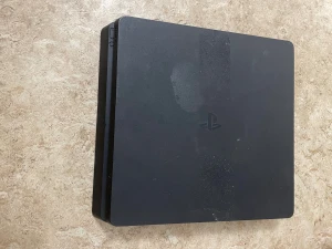 PlayStation 4 Slim - Sony PlayStation 4 Slim i svart färg. Konsolen har synliga märken och ytslitage på ovansidan, men är i fullt fungerande skick. Perfekt för dig som vill spela de senaste spelen till PS4. Kompakt design och tyst drift.