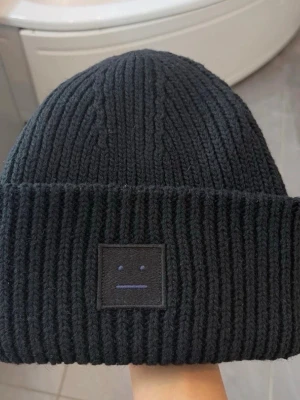 Svart stickad mössa Acne Studios - Svart ribbstickad mössa från Acne Studios, nyskick 