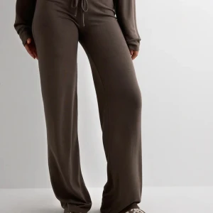 Bruna mjukisbyxor med snörning - Oanvända byxor från Nelly i storlek XS.