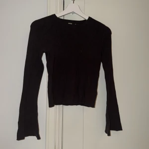 Svart stickad tröja från Bik Bok - En svart stickad tröja från Bik Bok med långärmad design och rund hals. Tröjan har en slim passform och är perfekt för lager på lager under höst och vinter. Enkel och stilren modell som passar till det mesta.