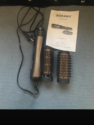 Stylingverktyg -2 borsta  för att lock o platta  - Sokany SD-903 roterande varmluftsborste med två utbytbara borsthuvuden. 1000W, 220-240V. Perfekt för styling och volym. Produkten ser välvårdad ut och levereras med original manual. Inga synliga defekter eller slitage på borstar eller handtag.