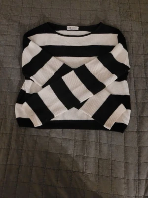 Randig svartvit stickad tröja H&M - Säljer en ribbstickad tröja från H&M i storlek 146/152. Tröjan har breda svarta och vita ränder, lång ärm och en klassisk rund halsringning. Perfekt för dig som gillar en enkel men snygg look.