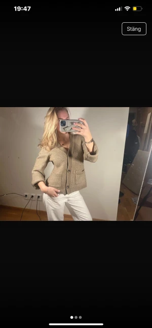 Beige stickad kofta med fickor - Säljer en beige stickad kofta med v-ringning och stora knappar framtill. Koftan har två praktiska fickor och ribbade muddar vid ärmslut och nederkant. Perfekt att slänga på sig över en t-shirt eller linne för en chill look.