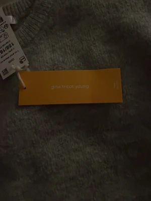 Ljusgrå stickad topp Gina Tricot Young - Säljer en ljusgrå stickad topp från Gina Tricot Young i storlek 158/164. Toppen har korta ärmar och Materialet är mjukt och har en melerad look som ger en modern känsla.helt ny aldrig använd 