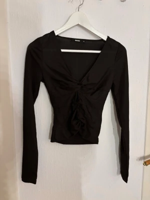 Svart/brun ribbad topp från BikBok - Svart/brun tight fest-topp med fina detaljer framtill. Storlek xs, från BikBok