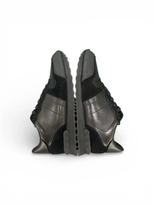 Valentino Garavani svarta sneakers - Säljer ett par svarta Valentino Garavani sneakers med coola nitar på sulan och detaljer i både mocka och skinn. Skorna har snörning och ett snyggt camouflage-mönster på ovandelen. Kommer med originalkartong. Perfekta för dig som gillar exklusiv streetstyle.