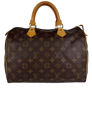 Louis Vuitton speedy 30 - Säljer en klassisk handväska från Louis Vuitton i brunt med ikoniskt monogrammönster. Väskan har två robusta handtag i ljusbrunt skinn och dragkedja upptill. Perfekt storlek för att få plats med allt du behöver och ger en lyxig vibe till din outfit. Se sista bilden, läderlappen är av men går enkelt att reparera. 