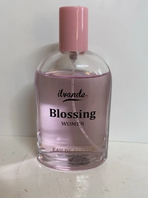 Blossing Women Eau de Parfum - Blossing Women från Ilvande är en Eau de Parfum med en rosa look, perfekt för dig som vill sticka ut. Flaskan rymmer 100 ml och är enkel att använda med sprayfunktion. Använd fåtal gånger, har inte orginalförpackningen men den har lukt av blommor. Vet inte exakt vilka men om man vill veta mer kan man söka upp. 