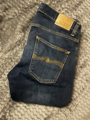 Nudie Jeans Grim Tim 30/34 - Säljer dessa Nudie jeans som är i riktigt bra skick. Modellen är Grim Tim å storleken är 30w 34L. Färgen är ”indigo myth” vilket är en fin mörkblå färg. 