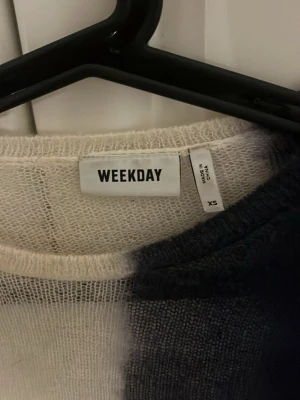 Vit och svart stickad tröja Weekday XS - Säljer en tunn, stickad långärmad tröja från Weekday i storlek XS. Tröjan har en cool tvåfärgad design med ena sidan vit och andra sidan svart/marinblå, vilket ger en unik look. Perfekt att styla med jeans för en trendig outfit. Jag har vanligtvis M och tröjan funkar men är förliten.