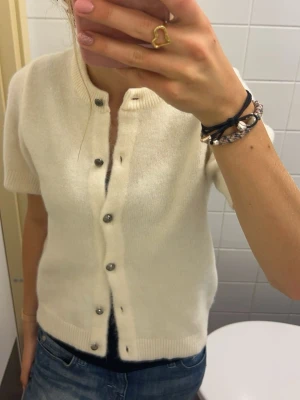 Stickad tröja  - Kortärmad stickad tröja med knappar från Gina! Kommer tyvärr inte till användning. Har haft den cirka 3 gånger så den är i fint skick 💕 nypris runt 400kr. Passar XS-S