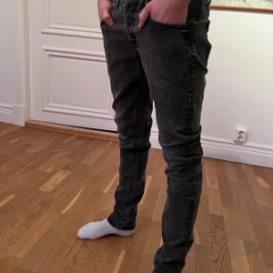 Dondup George - Säljer ett par svart/gråa dondup jeans (George) och har diskreta slitningar. Jeansen har en slim passform, låg midja. Snygga detaljer och det klassiska dondup märket. Nypris på dessa är ca: 3000kr  ,Mitt pris: 999kr🥵. Jeansen är väldigt populära just nu, och priset är inte hugget i sten 🪨Hör av er vid funderingar😊