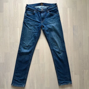 Blå Lee Daren jeans W31 L34 - Säljer ett par snygga blå jeans från Lee, modell Daren Zip Fly. Klassisk femficksdesign med raka ben och normal passform. Materialet är robust denim i bomull med dragkedja i gylfen. 