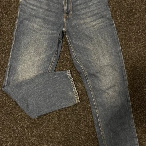 Blå jeans från Jack & Jones - Snygga blå jeans från Jack & Jones i klassisk straight fit. Jeansen har en normal passform, fem fickor och kontrastsömmar. Materialet är slitstarkt denim och färgen är en tvättad blå ton med lättare partier framtill och baktill.