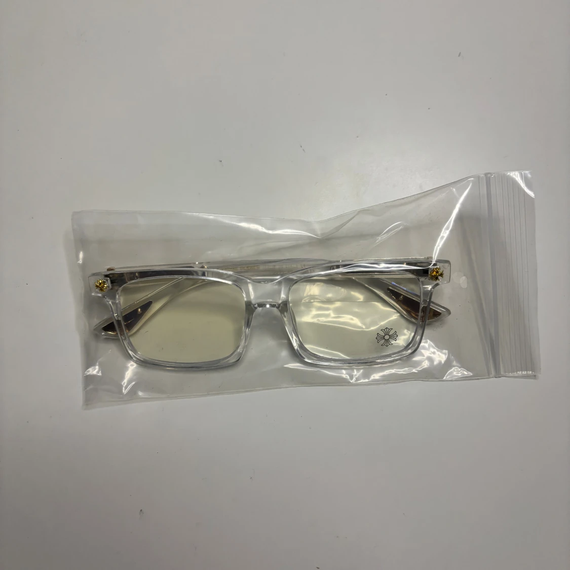 Transparenta glasögon med gulddetaljer