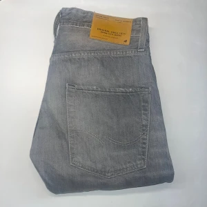 Jack & Jones jeans  - Snygga grå jeans från Jack & Jones, modell Erik Anti Fit. De har en klassisk femficksdesign, raka ben och normal passform. Jeansen är tillverkade i bomull och har en cool tvättad look med subtila slitningar. Midja 36cm, längd 91cm. Ifall det inte finns någon bild i annonsen där jag bär plaggen jag säljer så är det för att jag ej kan ha storleken heller passformen, så kolla måtten för storlek och googla på modellnamnet för passform 😉 41