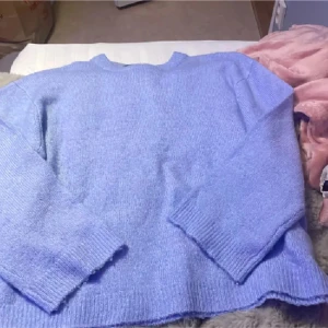 Blå stickad tröja 157 XS - Supermysig blå stickad tröja från 157 i storlek XS. Tröjan har rund hals, ribbade muddar och långärmade ärmar. Perfekt för dig som gillar chill och comfy vibes under höst och vinter. Enkel och stilren design som är lätt att matcha med jeans eller kjol.