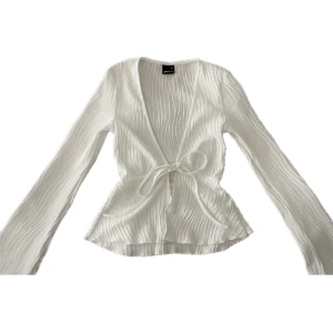 tie top - säljer en oanvänd tie top med utsvängda ärmar i storlek xs från gina tricot