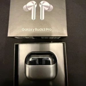 Galaxy Buds3 Pro - Samsung Galaxy Buds3 Pro trådlösa hörlurar i originalförpackning. Snygg och modern design, laddningsetui med USB-C. Produkten ser ut att vara i nyskick utan synligt slitage eller defekter. Perfekt för musik, samtal och aktiv livsstil.