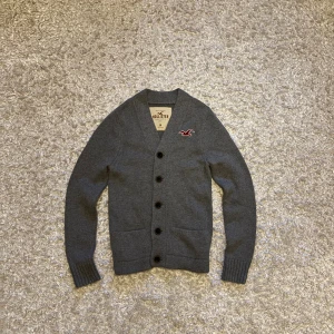 Grå stickad kofta från Hollister - Riktigt snygg o eftertraktad kofta/cardigan från Hollister. Den är i toppskick utan defekter. Storlek M, tveka inte på o skriva vid fler frågor!