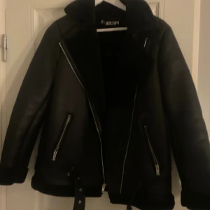 Svart pälsjacka från Pieces - Säljer en svart pälsjacka från Pieces med bred krage, synliga dragkedjor och detaljer i skinn. Jackan har två snedställda fickor med dragkedja och bälte nedtill. Jackan är använd fåtal gånger och är i storlek M. Pris går att diskutera vid snabb affär och har möjlighet att skicka samma dag!😇