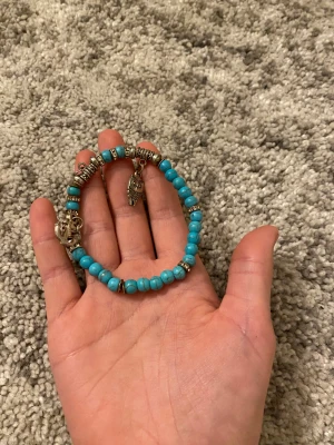 Turkost pärlarmband med berlocker.  - Fint armband med berlocker de är mycket bra skick. Köparen står för frakt