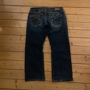Robins Jeans mörkblå jeans baggy - Benöppning: 24 cm Midja (rakt över): 47 cm Ytterbenslängd: 98,5 cm                                                             