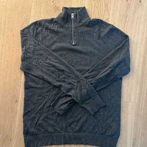 Grå Half zip - Säljer en mycket snygg och modern tröja från Jack and Jones. Tröjan är i mycket bra skick! Storleken är M och kan vara din för endast 299kr!
