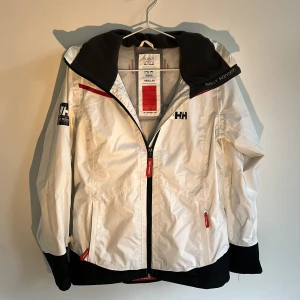 Vit vindjacka från Helly Hansen  - Snygg vit vindjacka från Helly Hansen. Väldigt bra kvalité. Väldigt snyggg