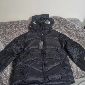 C.P Company puffer jacka helt ny - Helt ny C.p company jacka med tags och allting. Aldrig använd. Fick den som present, men den kom inte till användning. Jackan är väldigt fin och materialet värmer väldigt bra inför vintern.