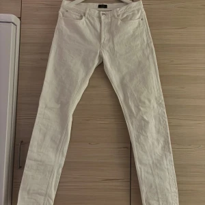 Vita jeans från A.P.C  - Snygga vita jeans från A.P.C. Petit New Standard i rak modell. Byxorna har klassisk femficksdesign, silverfärgad knapp och är tillverkade i 100% bomull. Vid frågor eller prisförslag, hör av er! 