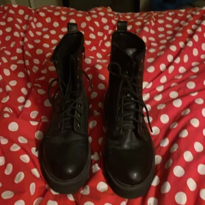 Svarta boots med platåsula och snörning - Säljer ett par svarta boots i skinn med grov platåsula. Skorna har snörning framtill, dragkedja på sidan och rund tå. Perfekta för dig som vill ha en edgy look och gillar chunky skor. Snygga till både jeans och kjol.