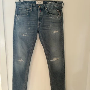 Replay Willbi Regular Slim Fit – Storlek 32/34 - Säljer ett par blå jeans från Replay i modellen Willbi Regular Slim Fit, storlek 32/34. Jeansen har en slim passform, klassisk femficksdesign och en snygg mellanblå tvätt med fabriks­gjorda slitningar för en stilren, användbar look. De är endast använda max tre gånger och är därför i mycket fint skick utan några egna skador eller hål. Nypris ligger på cirka 1 500–2 000 kr. Säljes då de tyvärr är för små för mig.