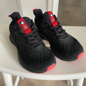 Träningssko från Gorilla Wear (stor i storlek) - Allsidig träningssko från Gorilla Wear med röda detaljer och snörning. En mycket lätt sko med ventilerande ovandel. Förstärkt häl för bättre stabilitet. Rymlig passform, så den är större än en normal 36:a. Då den är något för stor säljer jag den, endast använd ett 10-tal gånger. Mycket skön och lätt sko annars! Nypris 799:-