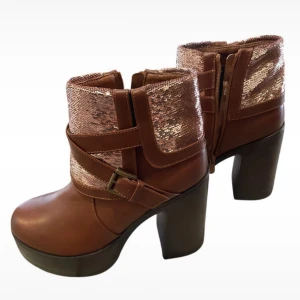 Bruna boots med paljettdetaljer - Snygga bruna boots med bred klack och plattform. Ovandelen har glittriga paljetter i roséguld och dekorativa remmar med spänne. Dragkedja på sidan för enkel på- och avtagning. Perfekt för dig som vill sticka ut med coola detaljer. Köpta second hand men aldrig använda!
