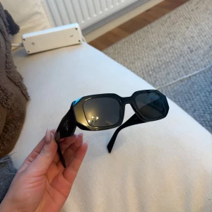 Svarta solglasögon från Prada - Nästan oanvända, max 5 ggr. Så helt nyskick. Nypris 2500-3000 kr ungefär. Helt äkta vilket man ser på skalmarna 😇Fler bilder vid önskemål.